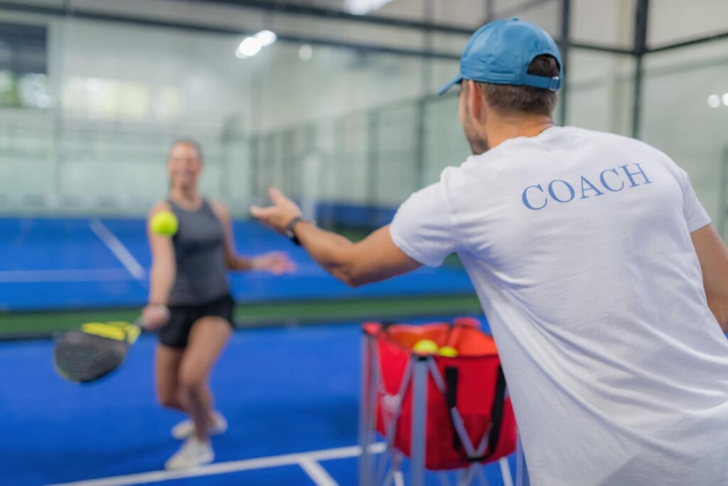 Padel coach training a player during a lesson on an indoor court at La Casa del Padel Cyprus.