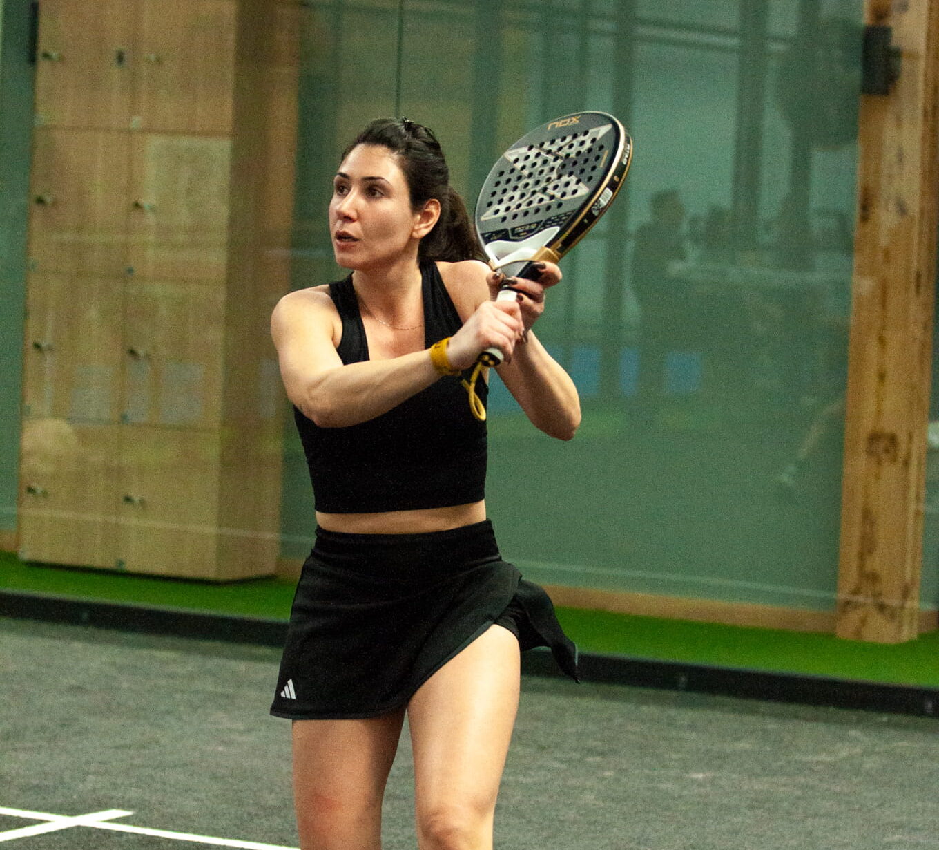 Maria Stylianou preparing a backhand shot during an indoor padel match at La Casa de Padel Cyprus.